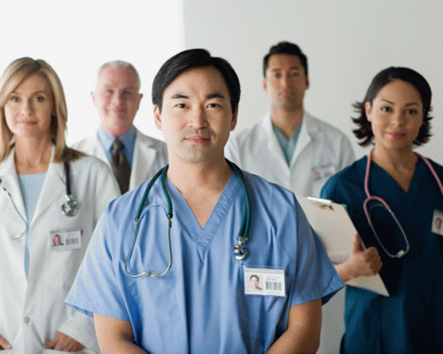 Ethnically diverse group of five standing Health Care Paracitioners with stethescopes and name badges